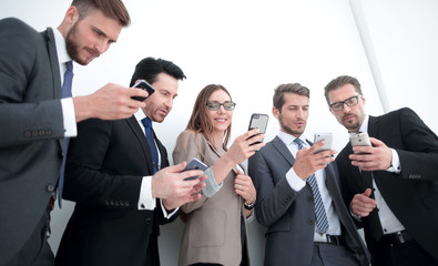 business team looking at the screens of their smartphones