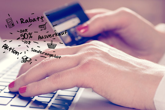 Eine Frau am Computer sucht online nach Rabatten und will mit Kreditkarte bezahlen