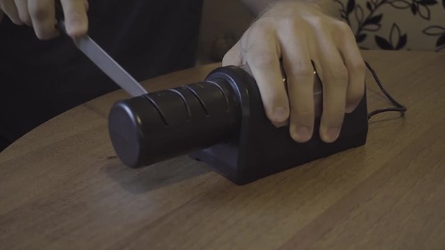 Sharpening a kitchen knife with an electronic sharpener