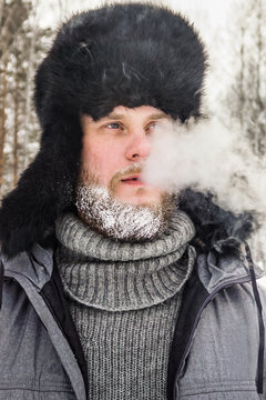 frozen man with a beard in winter in a forest with snowdrifts fell ill from the cold after a walk in the village