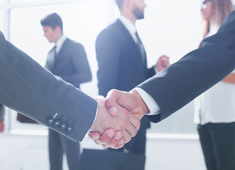 close up.handshake business partners in the background of the of