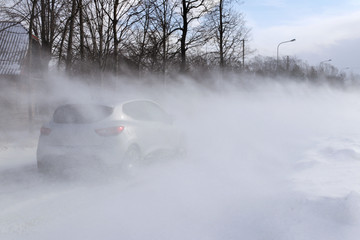 A car sneaks through drifts on a dangerous road covered with snow. Private transport is struggling...