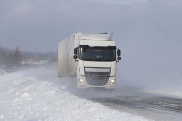 A large truck sneaks through snowdrifts on a dangerous road covered with snow. TIR fights the...