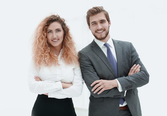 two young business people stand with arms folded