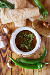Delicious hearty soup with meat in a traditional pot on the table in the restaurant.