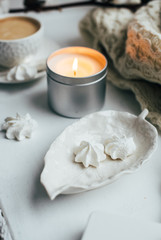 Cozy winter home interior with knitted blanket and candle