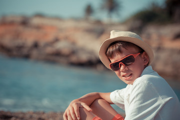 Fototapeta na wymiar Portrait of teenager sitting near sea, outdoor