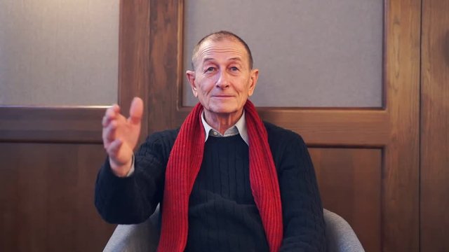 Businessman presentating business company. Senior man speaks to camera.