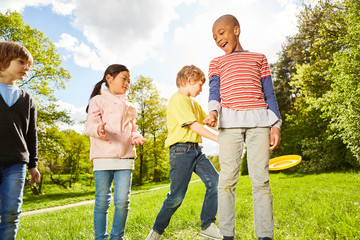 Fototapeta premium Kinder im Kindergarten spielen Frisbee im Park