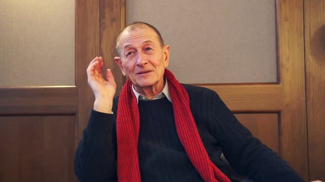 Businessman presentating business company. Senior man speaks to camera.