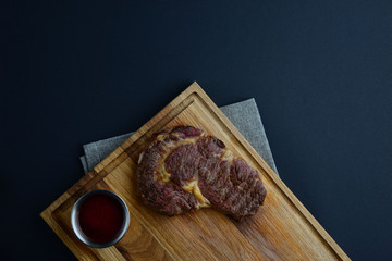 Chopping board with roasted meat and sauce