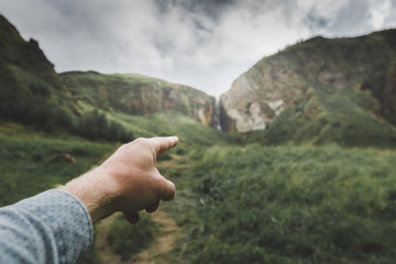 Male hand indicates the direction of movement, point of view shot. Travel Adventure Journey Concept