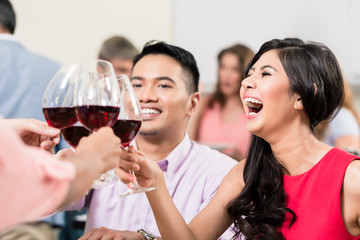 Happy young woman toasting wineglasses with friends