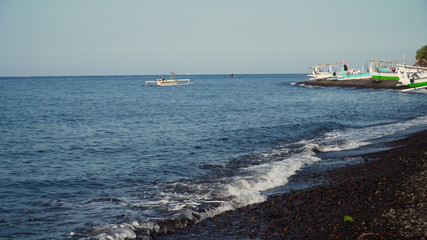Shore with beach and fishing boats. tropical landscape coastline with black volcanic sand