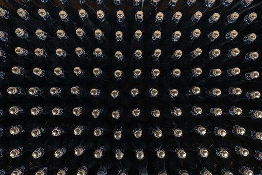 Pattern of sparkling wine bottles seen from above