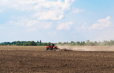 Farmer in tractor preparing land with seedbed cultivator