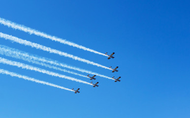 Airshow. White smoke trail of six planes on the blue sky