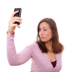 Fototapeta premium young woman making silly face while taking a self portrait with her smart phone