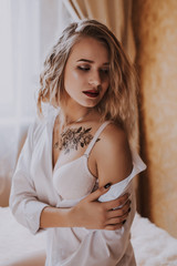 Naklejka premium Beautiful girl in a white shirt on the bed
