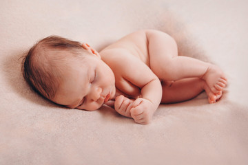 newborn baby lying. Imitation of a baby in the womb. beautiful little child sleeping lying on her tummy.