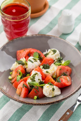 Caprese salad with mozzarella, tomato, basil and balsamic vinegar served on the table