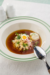 Summer cold soup okroshka with egg, radish, cucumber and dill served on the table
