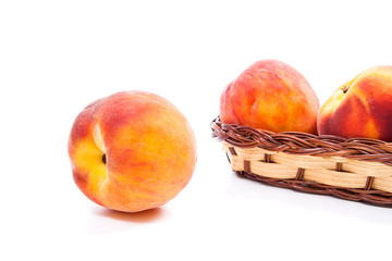 Single ripe peach fruit and several in basket isolated on white background.