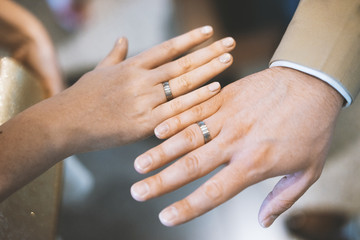 Young couple showing hands with wedding rings