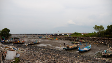 Harbor at low tide with fishing boats waiting high tide. fishing boats in dry harbour at low tide