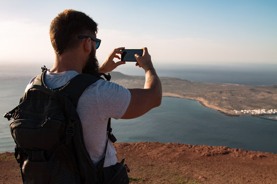 Silhouette of a man on the background of the Atlantic Ocean and the island of La Graciosa. Mountain. Mirador del Rio. North of Lanzarote. Canary Islands. Spain