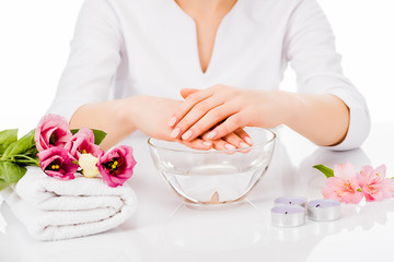 Obraz na płótnie Canvas Cropped view of manicurist posing with bowl of water and towel isolated on white