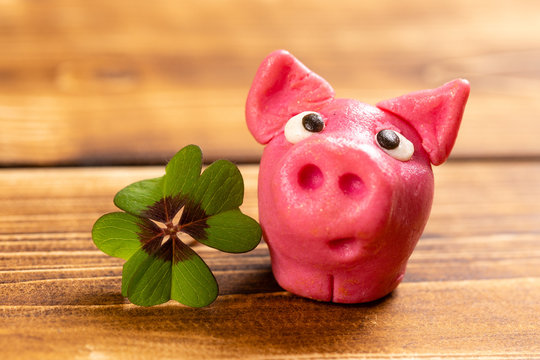 green shamrock with lucky pig on a wooden background