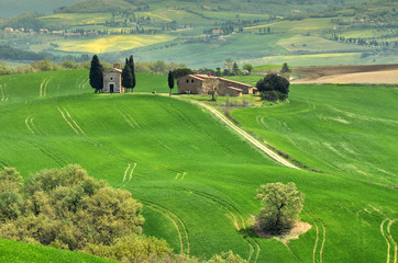Cappella Di Vitaleta or Vitaleta Chapel near San Quirico D'Orcia in Tuscany. Green hill with the famous Chapel on background.