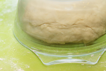 The raw dough is infused under a glass plate for making homemade dumplings