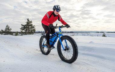 A young man riding fat bicycle in the winter. Fat tire bike.	