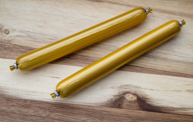 Fish sausage on wooden background.