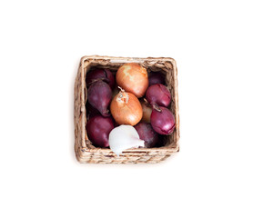 Purple and white onions in squar, wicker box isolated on white background.