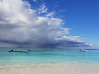 boats in caribbean sea under stormy clouds