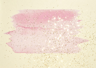Abstract pink watercolor splash and golden glitter in vintage nostalgic colors.