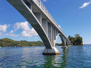 under big white bridge on atlantic ocean connecting two islands in caribbean area next to dominican republic