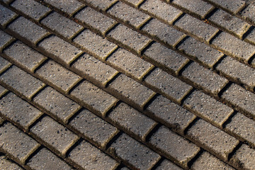 Rectangular cobblestone pattern on the street. Abstract background of grey cobble pavement.