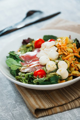 Salad with fusilli pasta accompanied tomatoes, mozzarella, smoked ham and italian cheese