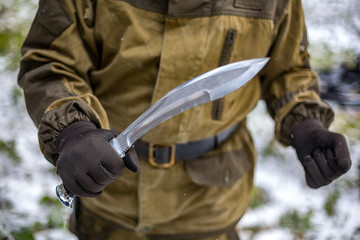 the hunter in the winter forest gets a big knife