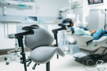 Fototapeta na wymiar Patient on chair in dental clinic, back view