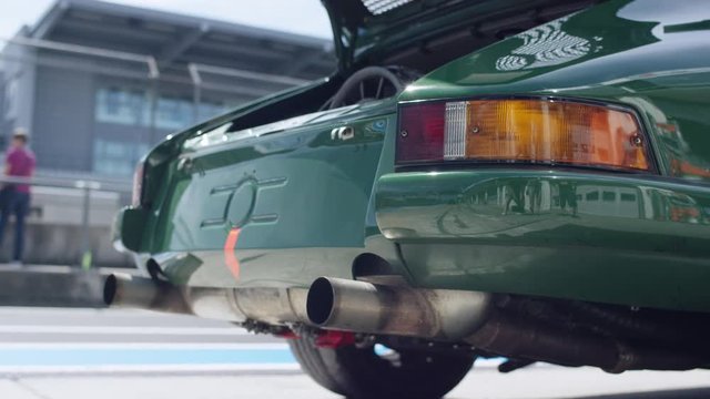 Rear of a sports car on the race track with the engine on display - Heck eines Sportwagens auf der Rennstrecke mit offengelegtem Motor
