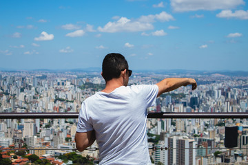 Fototapeta na wymiar A man in the highest place in the city pointing to the town 