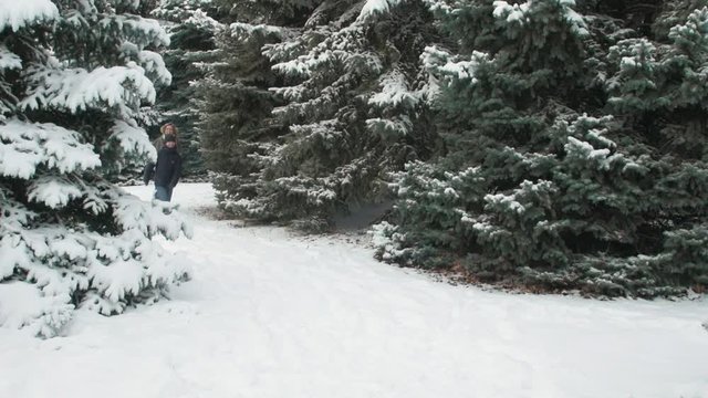 Family rests in winter forest, beautiful landscape with snowy fir trees
