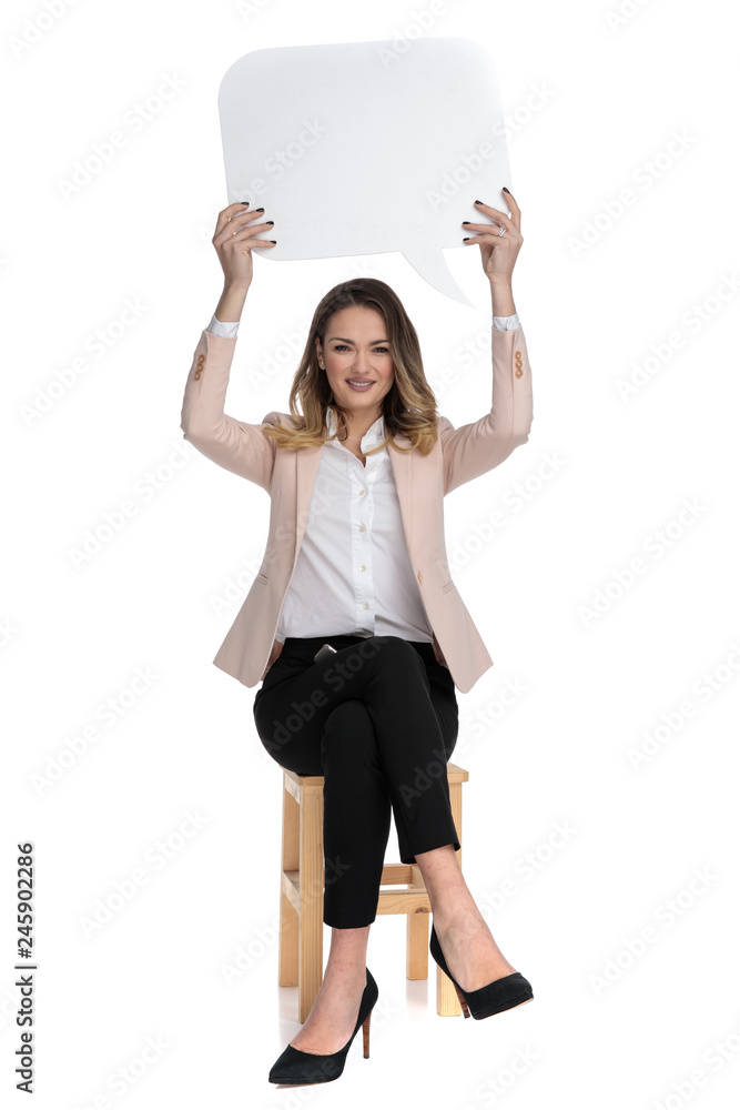 Sticker young businesswoman sits and holds speech bubble in the air