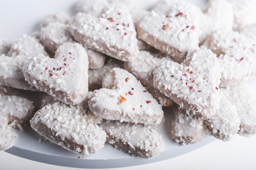  Valentine's day white coconut heart shaped cookies with red and pink heart sprinkles. Copy space