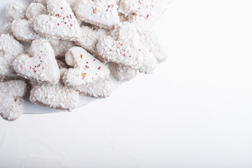  Valentine's day white coconut heart shaped cookies with red and pink heart sprinkles. Copy space